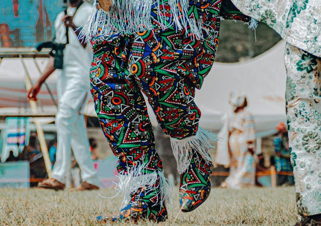 Traditional masquerade dancers in vibrant, colorful costumes at a cultural event in Nigeria.