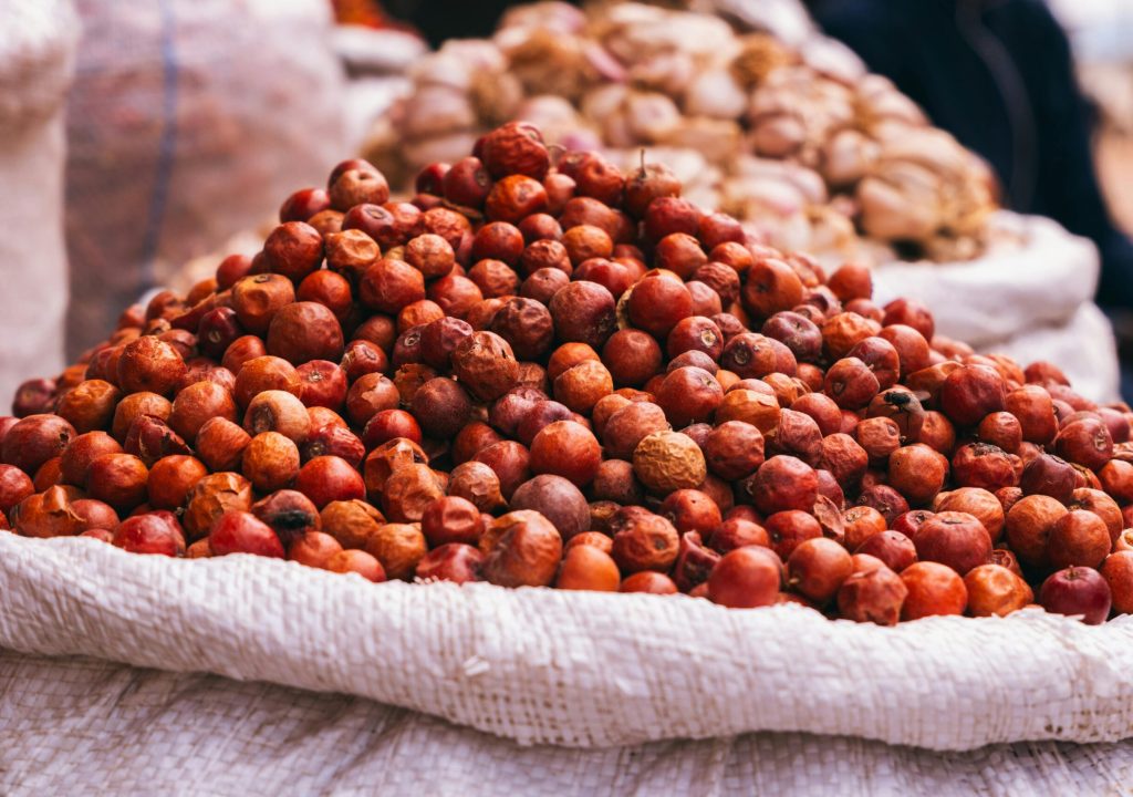 Close-up of locust bean pods stacked in sacks at a market in Jos, Nigeria.